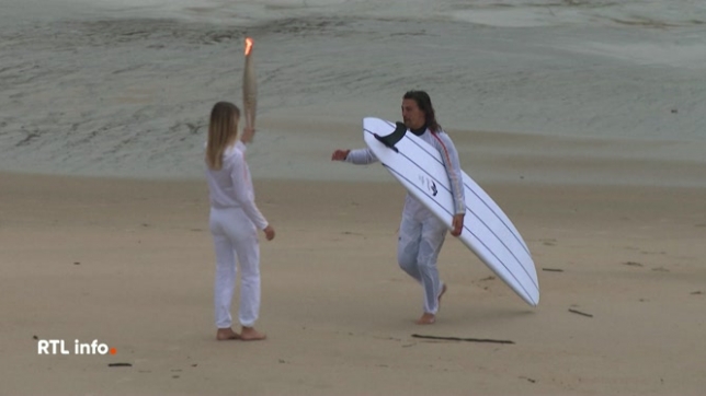 JO de Paris: des surfeurs se passent la flamme sur la plage de Biarritz