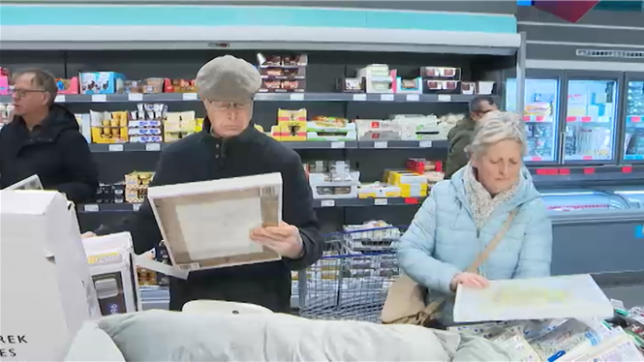 Devant le supermarché Aldi, des gens attendent l'ouverture. Tous ont le même objectif : acheter la lithographie de l'artiste Koen Van Mechelen.