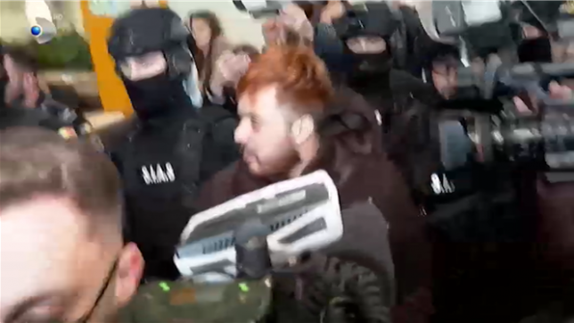 Le narcotrafiquant Mohamed Amra est escorté par la police jusqu'à l'aéroport de Bucarest, en Roumanie. Il devrait être remis dans les prochaines heures aux autorités françaises.