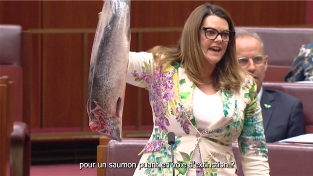 Une sénatrice écologiste australienne brandit un saumon mort dans l'hémicycle du Sénat, accusant le gouvernement de s'être laissé prendre au piège de la pollution des fermes piscicoles industrielles.