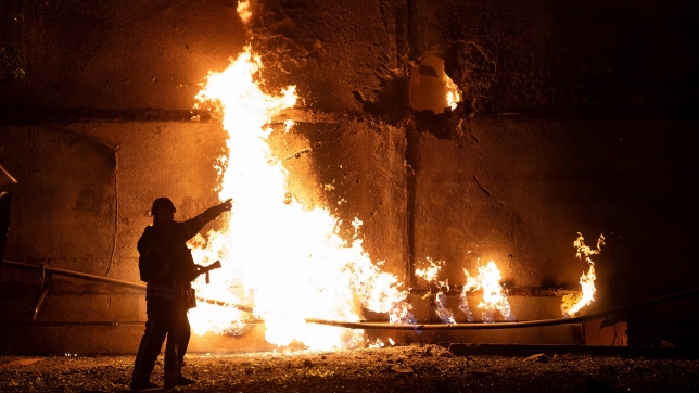 Un pompier se tient près d’un feu et montre un trou après une attaque de drone à Kharkiv le 5 juin 2025, dans le cadre de l’invasion russe en Ukraine.