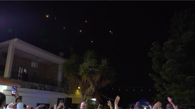 Une salve de missiles iraniens traverse le ciel au-dessus de la frontière entre le Liban et Israël, alors que les invités d'un mariage dans un village de Marjayoun, situé près de la frontière israélienne,  interrompent la musique pour regarder le ciel.