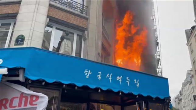 La façade d'un immeuble situé près de la place du Châtelet dans le centre de Paris est en flammes, alors que des manifestants font face à des policiers à proximité dans le cadre de la mobilisation Bloquons tout.