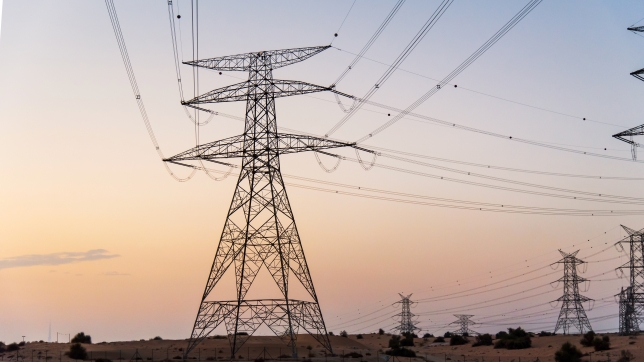 Electricity overhead power lines in the desert at sunset