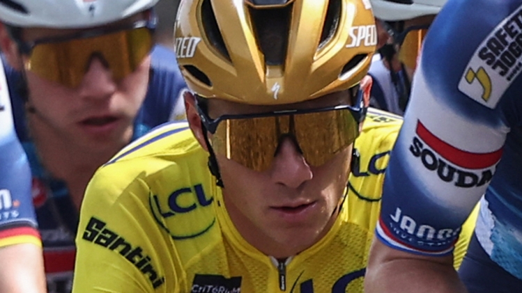 Soudal Quick-Step's Belgian rider Remco Evenepoel (C) wearing the overall leader's yellow jersey cycles with the pack during the 5th stage of the 77th edition of the Criterium du Dauphine cycling race, 183 km between Saint-Priest and MÃ¢con, on June 12, 2025. (Photo by Anne-Christine POUJOULAT / AFP)