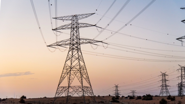 Electricity overhead power lines in the desert at sunset