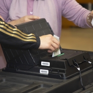 Un homme met le bulletin imprimé de son vote électronique dans l’urne alors qu’il vote dans un bureau de vote à Koekelberg, Bruxelles, dimanche 26 mai 2019.