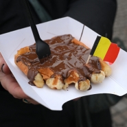 A tourist holds a Belgian waffle in the historical district in Bruges on December 30, 2024. (Photo by Nicolas TUCAT / AFP) liège balls soon ... space? liège balls soon ... space? new