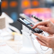 une-jeune-femme-dans-le-magasin-se-tient-pres-du-stand-et-choisit-un-telephone.jpg