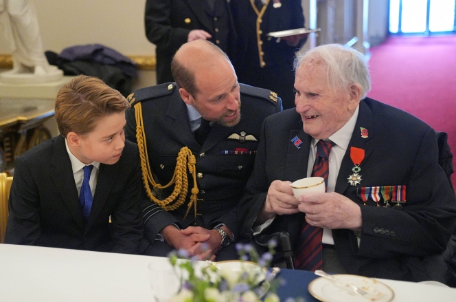 Le prince George de Galles et le prince William de Galles s’entretiennent avec des vétérans de la Seconde Guerre mondiale lors d’un goûter organisé au palais de Buckingham le 5 mai 2025 pour célébrer le 80e anniversaire du jour de la Victoire en Europe, qui a marqué la fin de la Seconde Guerre mondiale en Europe.