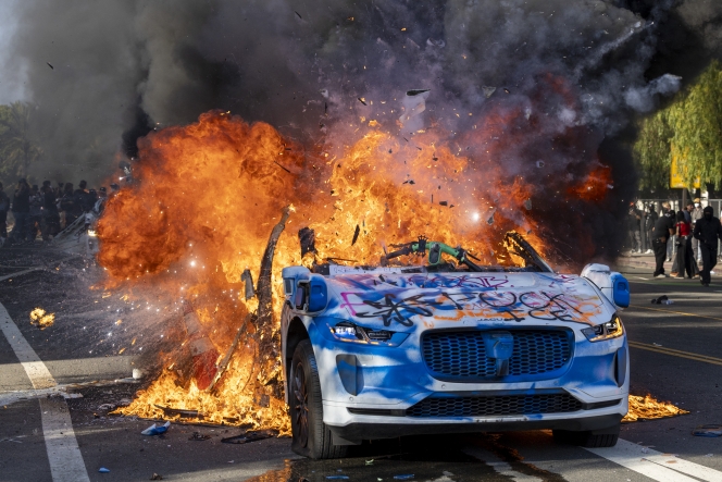 A Waymo vehicle is burning, as protesters clash with law enforcement in the streets surrounding the federal building during a protest following federal immigration operations in Los Angeles, California, on June 8, 2025. Demonstrators torched cars and scuffled with security forces in Los Angeles on June 8, as police kept protestors away from the National Guard troops President Donald Trump sent to the streets of the second biggest US city. (Photo by RINGO CHIU / AFP)