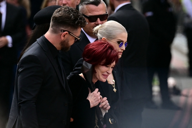 La famille d’Ozzy Osbourne, son fils Jack Osbourne, sa veuve Sharon Osbourne et sa fille Kelly Osbourne arrivent pour déposer des fleurs sur le banc du Black Sabbath Bridge, situé sur Broad Street, lors du cortège funèbre d’Ozzy Osbourne, le défunt chanteur principal de Black Sabbath, à Birmingham, dans le centre de l’Angleterre, le 30 juillet 2025.